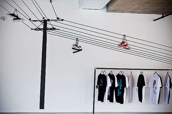 Nice Kicks Custom Wall Decal with actual shoe display hanging from wires and custom piping merch display